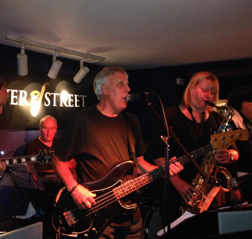 John Davies playing bass guitar and singing